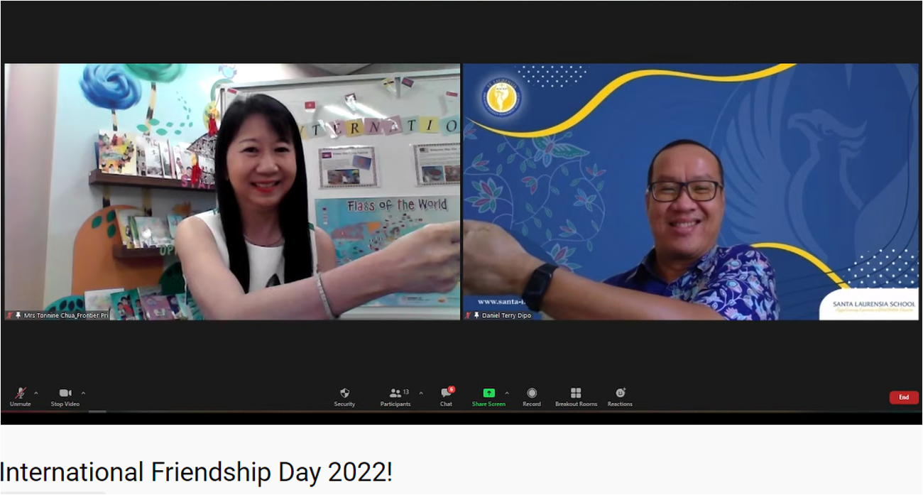 Two people on a Zoom call for International Friendship Day 2022, one in a classroom and one with a blue school backdrop.